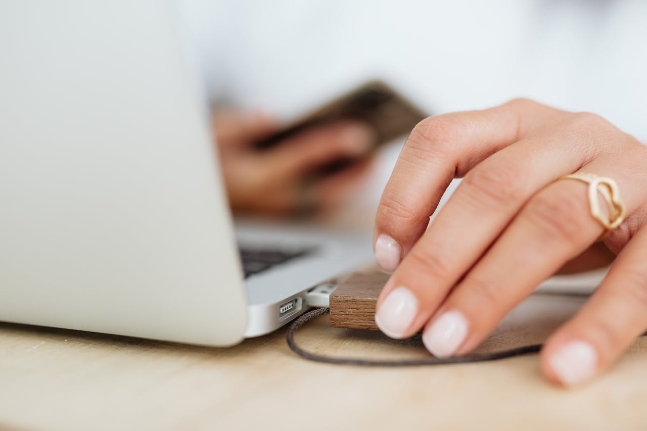 Crafting Captivating Headlines: Your awesome post title goes here Close-up of a woman's hand with a ring inserting a USB drive into a laptop.