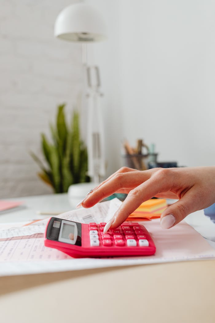 The Art of Drawing Readers In: Your attractive post title goes here Close-up of a hand pressing buttons on a pink calculator on a desk, indoors.